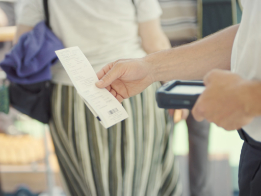 Ticketscan Beim Zustieg auf einem Schiff wird ein Ticket gescannt. Ein Mitarbeiter hält mit der linken Hand den Scanner und mit der rechten Hand das Ticket.